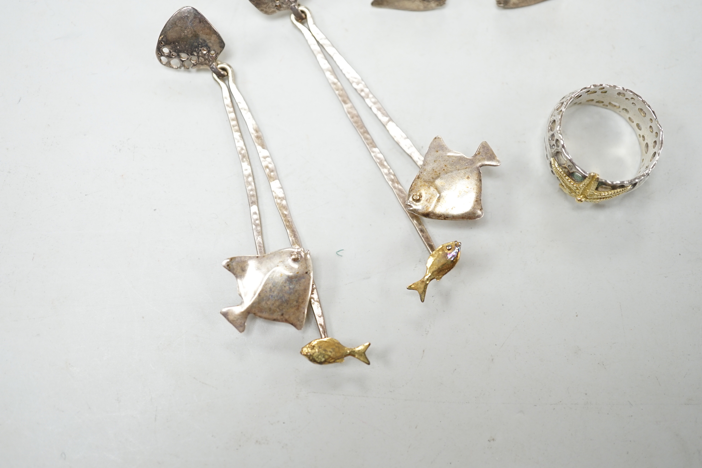 A modern Alan Vallis parcel gilt silver ring, with starfish motif, size O and two pairs of Alan Vallis silver earrings, both modelled with fish, longest overall 74mm.